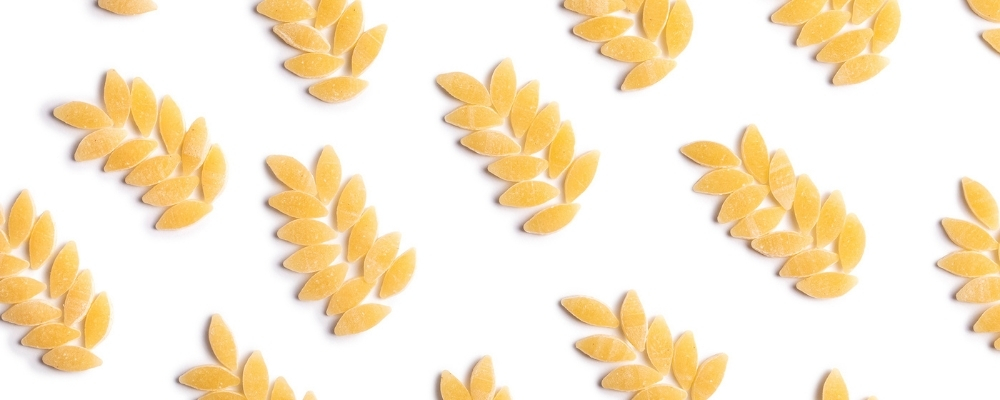 Immagine creativa di spighe di grano replicate in un pattern con chicchi di pasta Mancini